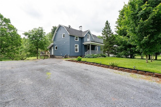 view of property exterior featuring a yard and a balcony