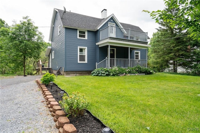 back of house featuring a yard and a balcony