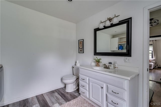 bathroom with hardwood / wood-style floors, vanity, and toilet