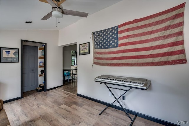 hallway featuring vaulted ceiling and light hardwood / wood-style flooring