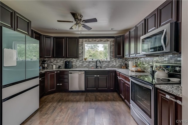 kitchen featuring sink, ceiling fan, decorative backsplash, dark hardwood / wood-style flooring, and stainless steel appliances