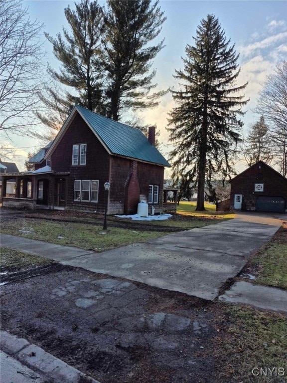 property exterior at dusk featuring an outbuilding and a garage