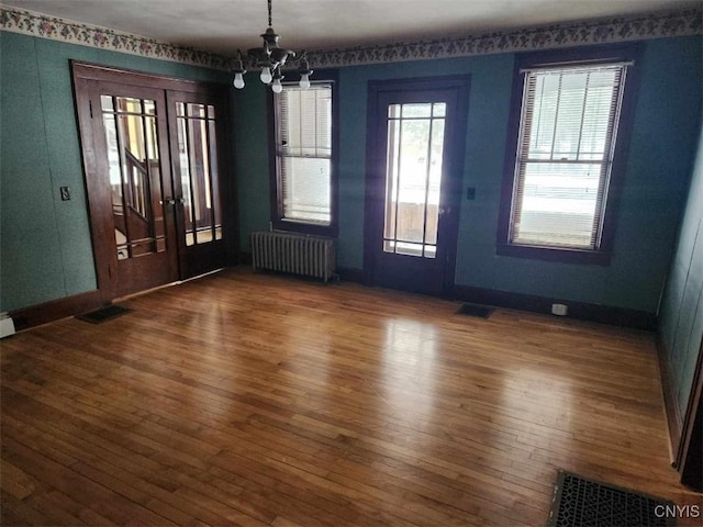 foyer entrance with a chandelier, radiator heating unit, and dark hardwood / wood-style floors