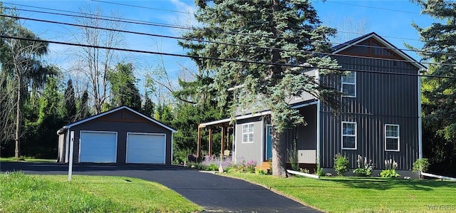 front of property featuring a garage, a front lawn, and an outdoor structure