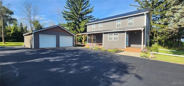 front of property with a porch, an outdoor structure, and a garage