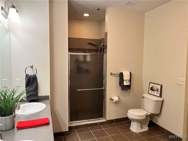 bathroom with tile patterned flooring, vanity, toilet, and walk in shower