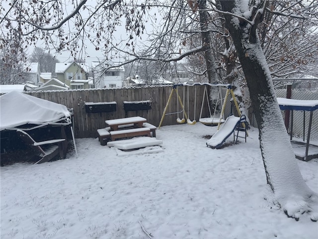 yard layered in snow with a playground