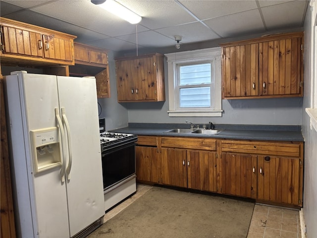 kitchen with sink, a drop ceiling, and white appliances