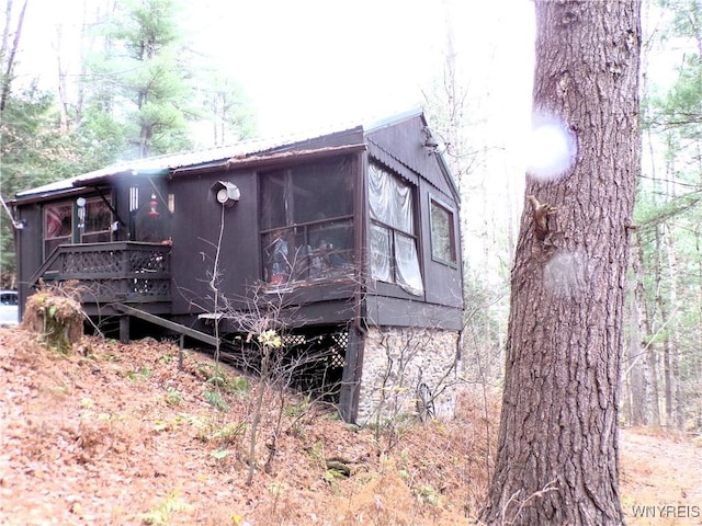 view of side of property with a wooden deck and a sunroom