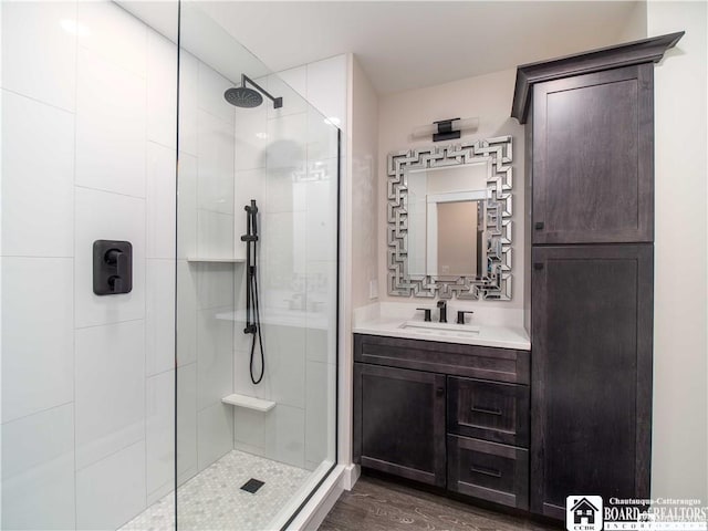 bathroom with an enclosed shower, vanity, and hardwood / wood-style floors