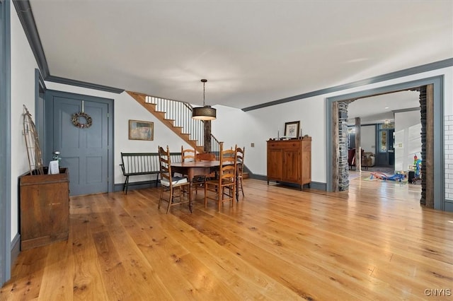 dining room featuring light hardwood / wood-style floors and crown molding