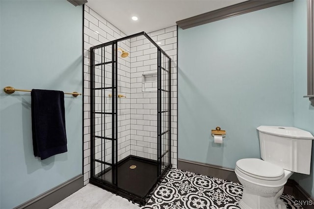 bathroom featuring toilet, a tile shower, tile patterned floors, and ornamental molding