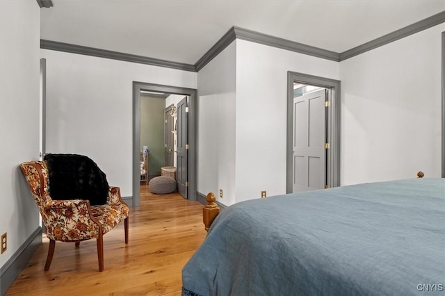 bedroom with ensuite bathroom, hardwood / wood-style floors, and ornamental molding