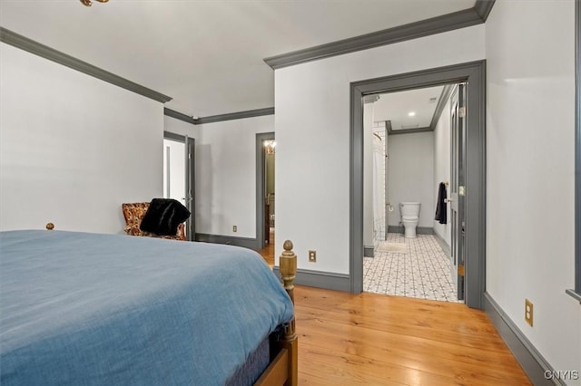 bedroom featuring light wood-type flooring, crown molding, and connected bathroom