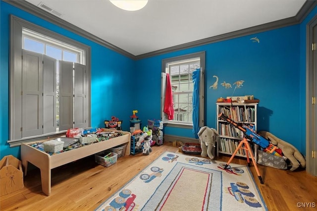 game room with hardwood / wood-style floors and ornamental molding