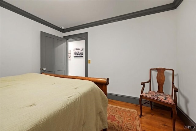 bedroom with hardwood / wood-style floors and ornamental molding