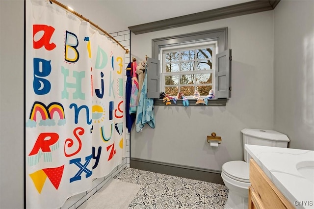 bathroom featuring tile patterned floors, walk in shower, vanity, crown molding, and toilet