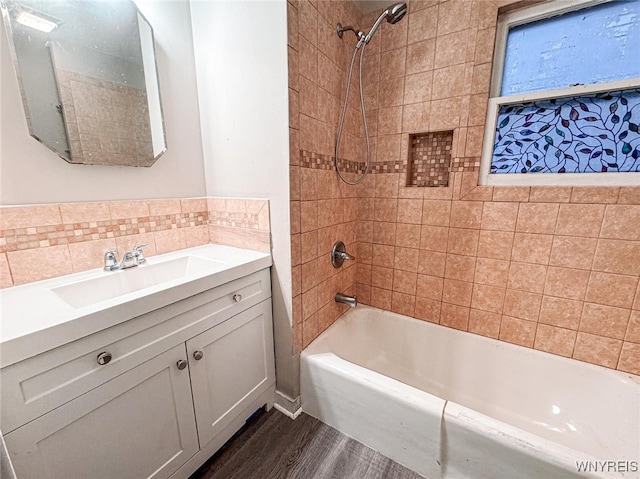 bathroom with vanity, wood-type flooring, and tiled shower / bath