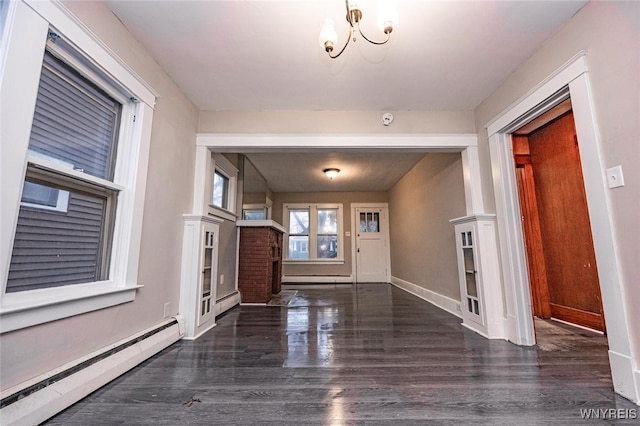 entrance foyer with dark hardwood / wood-style flooring, an inviting chandelier, and a baseboard heating unit