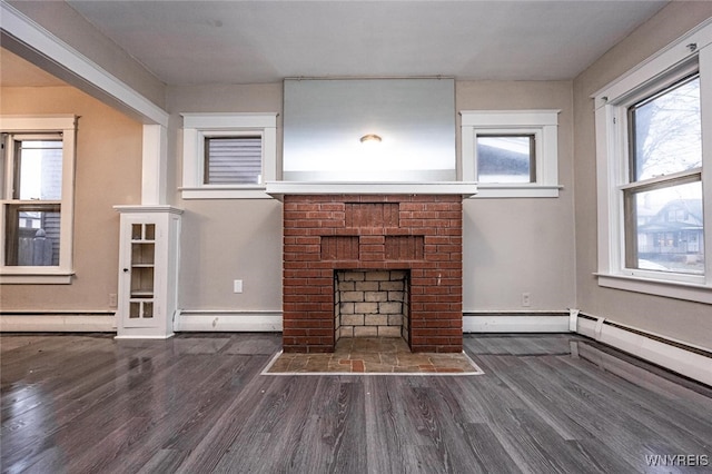 unfurnished living room featuring dark hardwood / wood-style floors, a healthy amount of sunlight, a fireplace, and a baseboard radiator