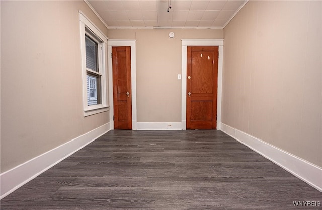 corridor with dark hardwood / wood-style flooring and ornamental molding