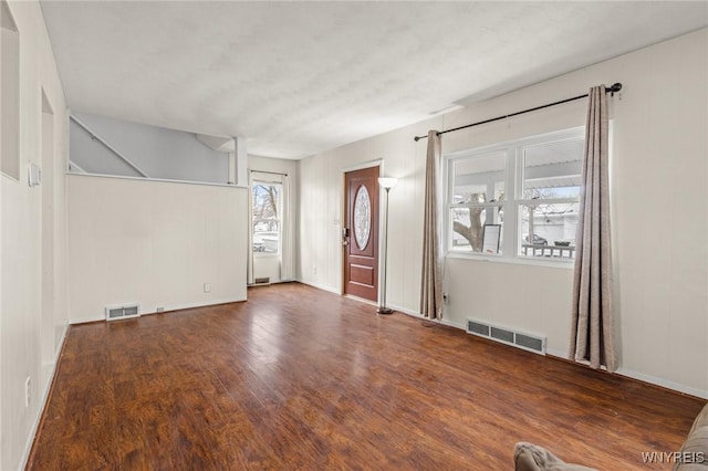 unfurnished room with dark wood-type flooring and a wealth of natural light