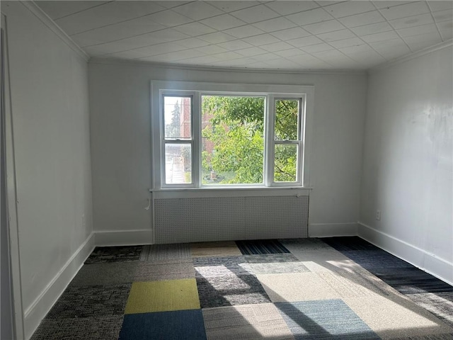 carpeted spare room featuring radiator heating unit and ornamental molding