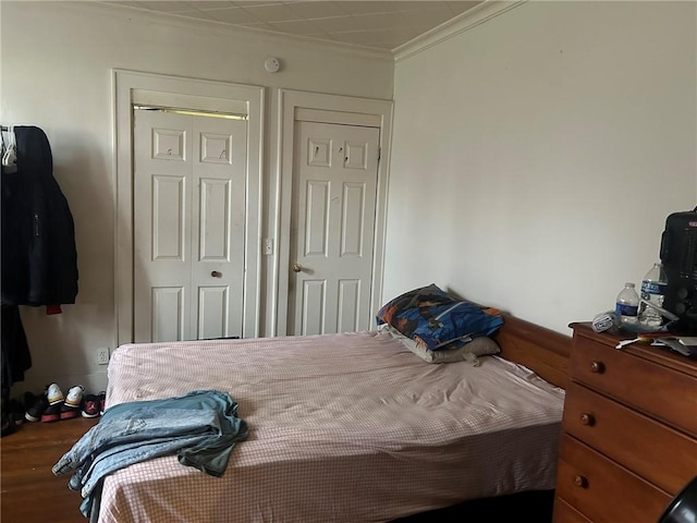 bedroom featuring dark hardwood / wood-style flooring, a closet, and ornamental molding