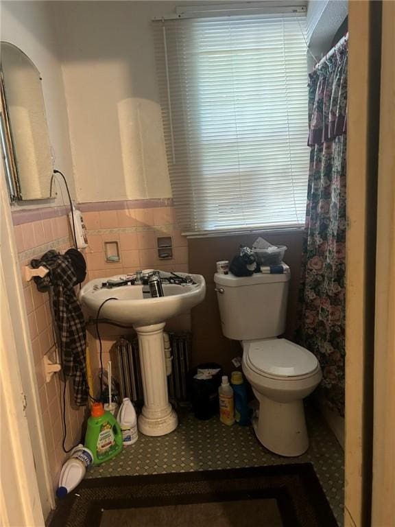 bathroom featuring tile patterned floors, toilet, tile walls, and curtained shower