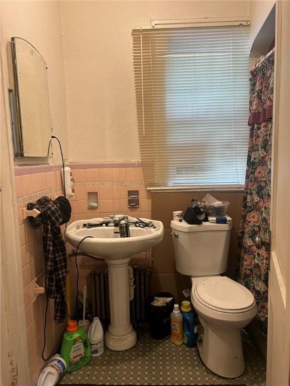 bathroom with sink, toilet, tile walls, and tile patterned floors