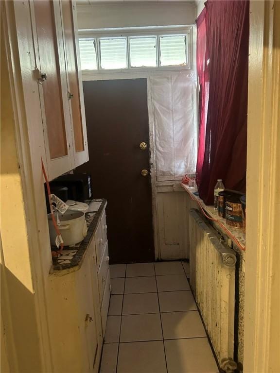 entryway featuring radiator heating unit and light tile patterned floors