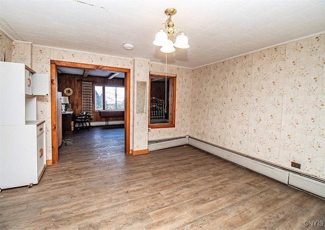 empty room with hardwood / wood-style floors and an inviting chandelier