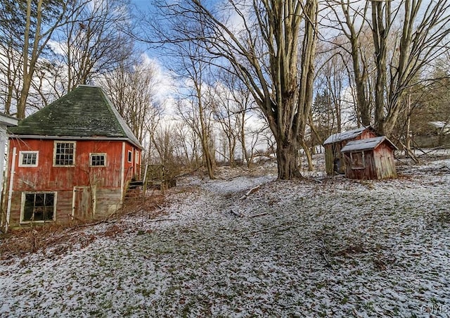 yard layered in snow with a storage shed