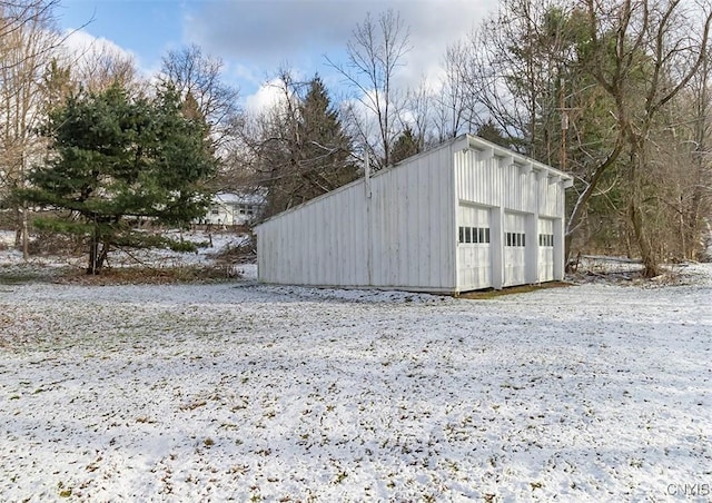 snow covered structure featuring a garage