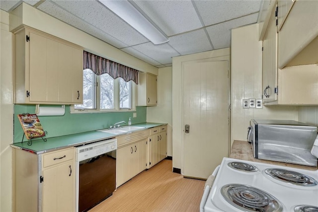 kitchen featuring a paneled ceiling, dishwasher, cream cabinets, electric stove, and sink