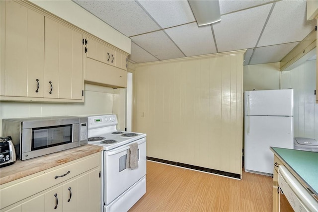 kitchen featuring a drop ceiling, light wood-type flooring, white appliances, and cream cabinetry