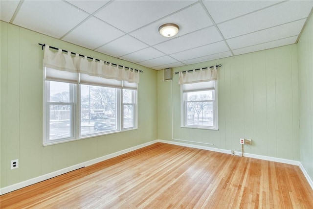 unfurnished room featuring hardwood / wood-style floors and a paneled ceiling