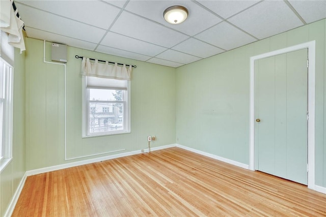 unfurnished room with hardwood / wood-style floors and a paneled ceiling