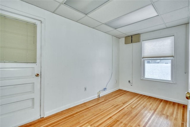 empty room with a paneled ceiling and wood-type flooring