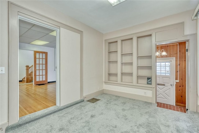 unfurnished room featuring carpet and built in shelves