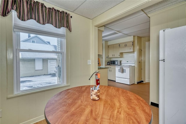 dining area with light hardwood / wood-style flooring and a drop ceiling