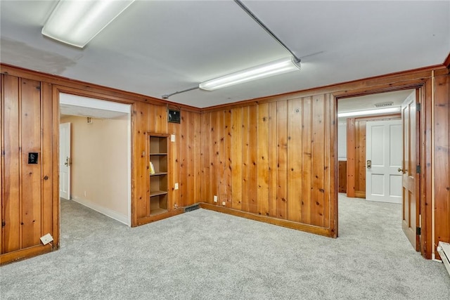 basement featuring light carpet and wooden walls