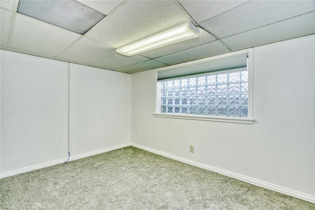 carpeted empty room with a drop ceiling