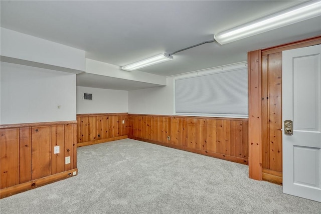 empty room with light carpet and wood walls