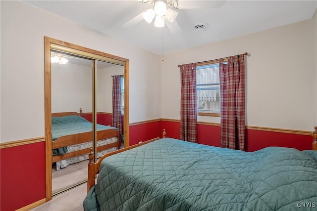 bedroom with a closet, ceiling fan, and carpet flooring