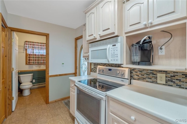 kitchen with baseboard heating, white appliances, white cabinetry, and tasteful backsplash