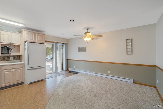 kitchen with baseboard heating, backsplash, ceiling fan, and white fridge