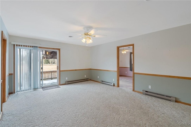 carpeted spare room with ceiling fan and a baseboard heating unit