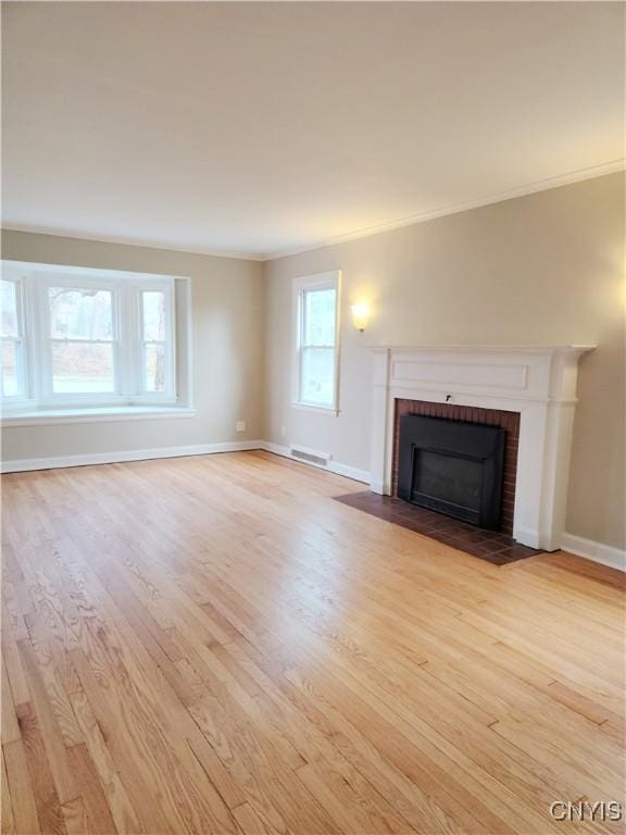 unfurnished living room with a fireplace, light hardwood / wood-style flooring, and crown molding