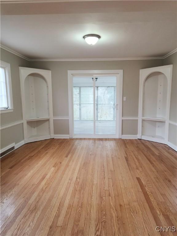 interior space with a healthy amount of sunlight, light wood-type flooring, and crown molding